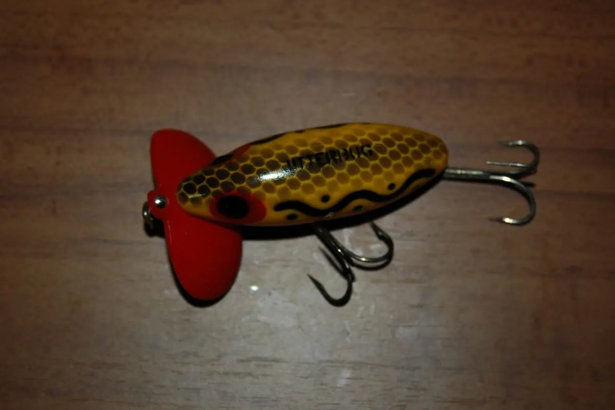 Arbogast Jitterbug topwater lure with a red cupped lip and frog pattern body